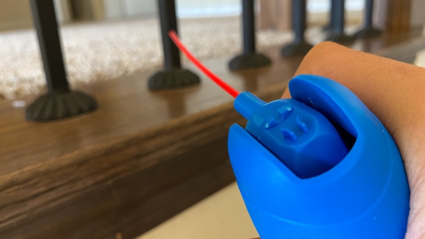Close up view of household using the air duster to clean the corner of the stairs